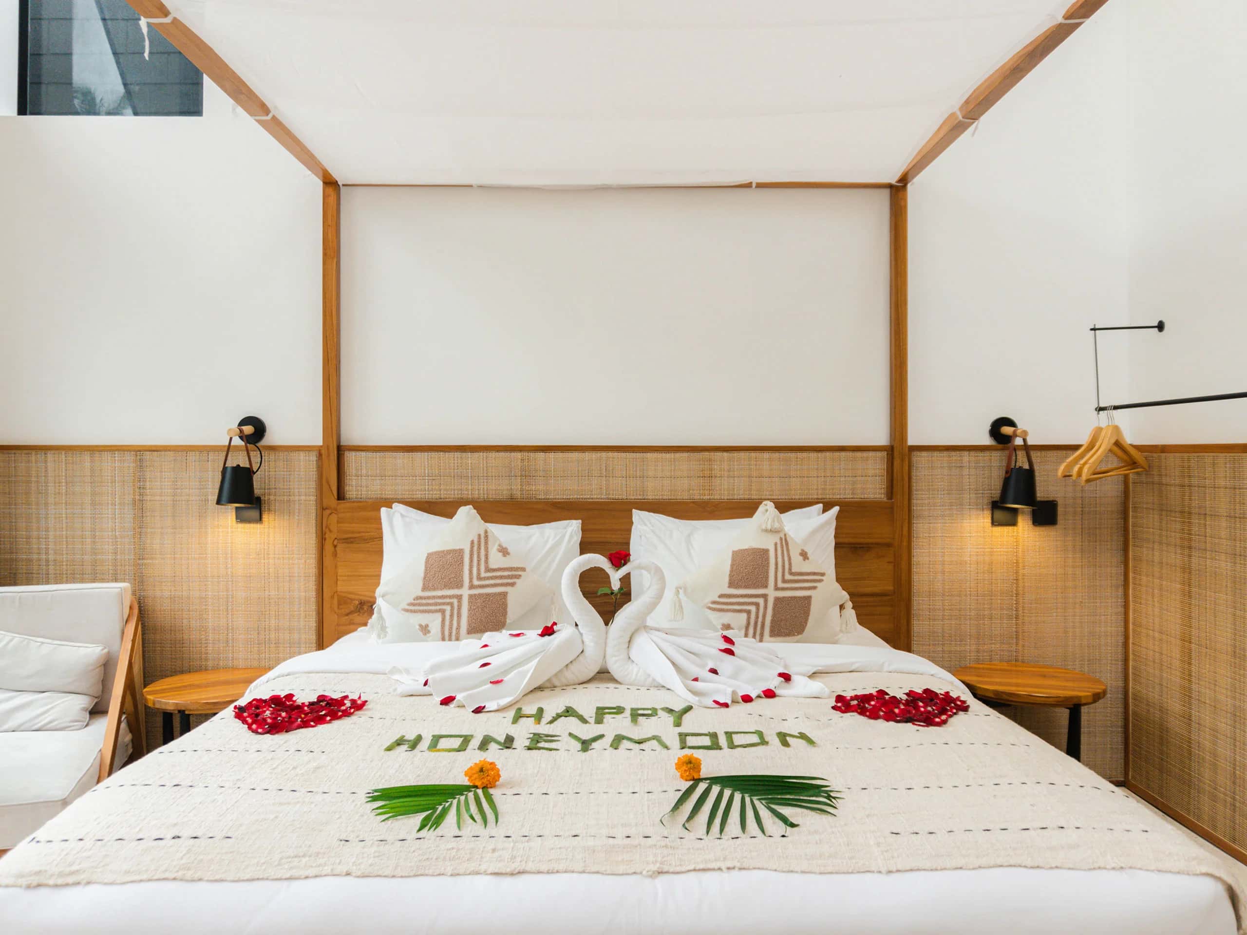 Honeymoon bed setup with rose petals and swan towels at Tannari Villas