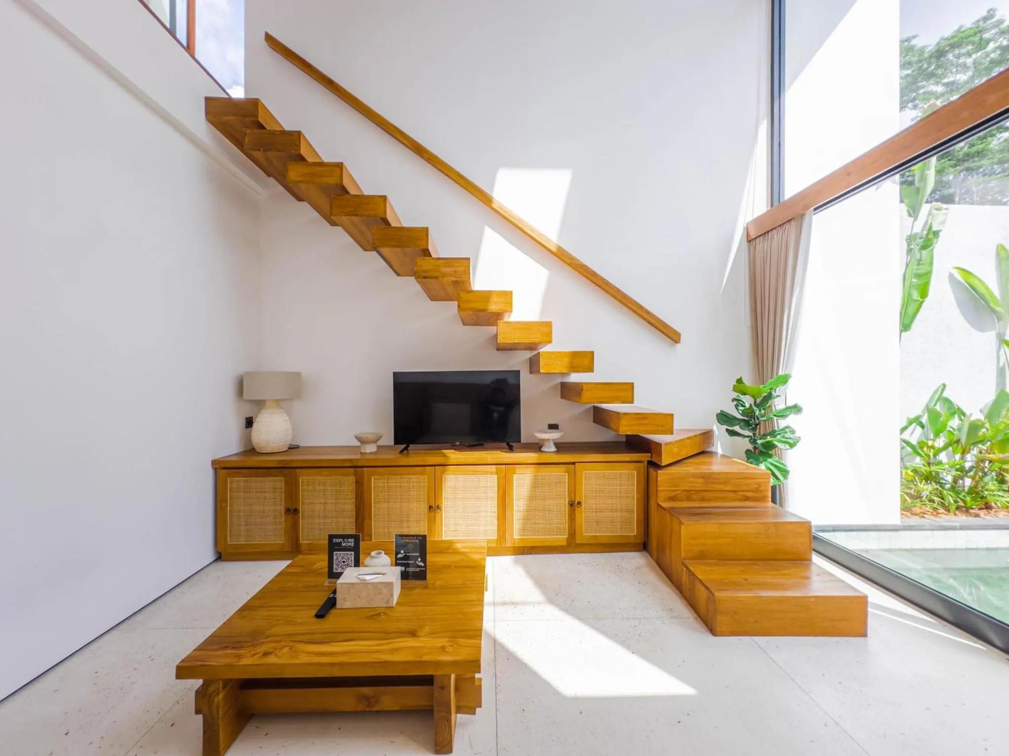 Mezzanine living room with a wooden table and floating staircase