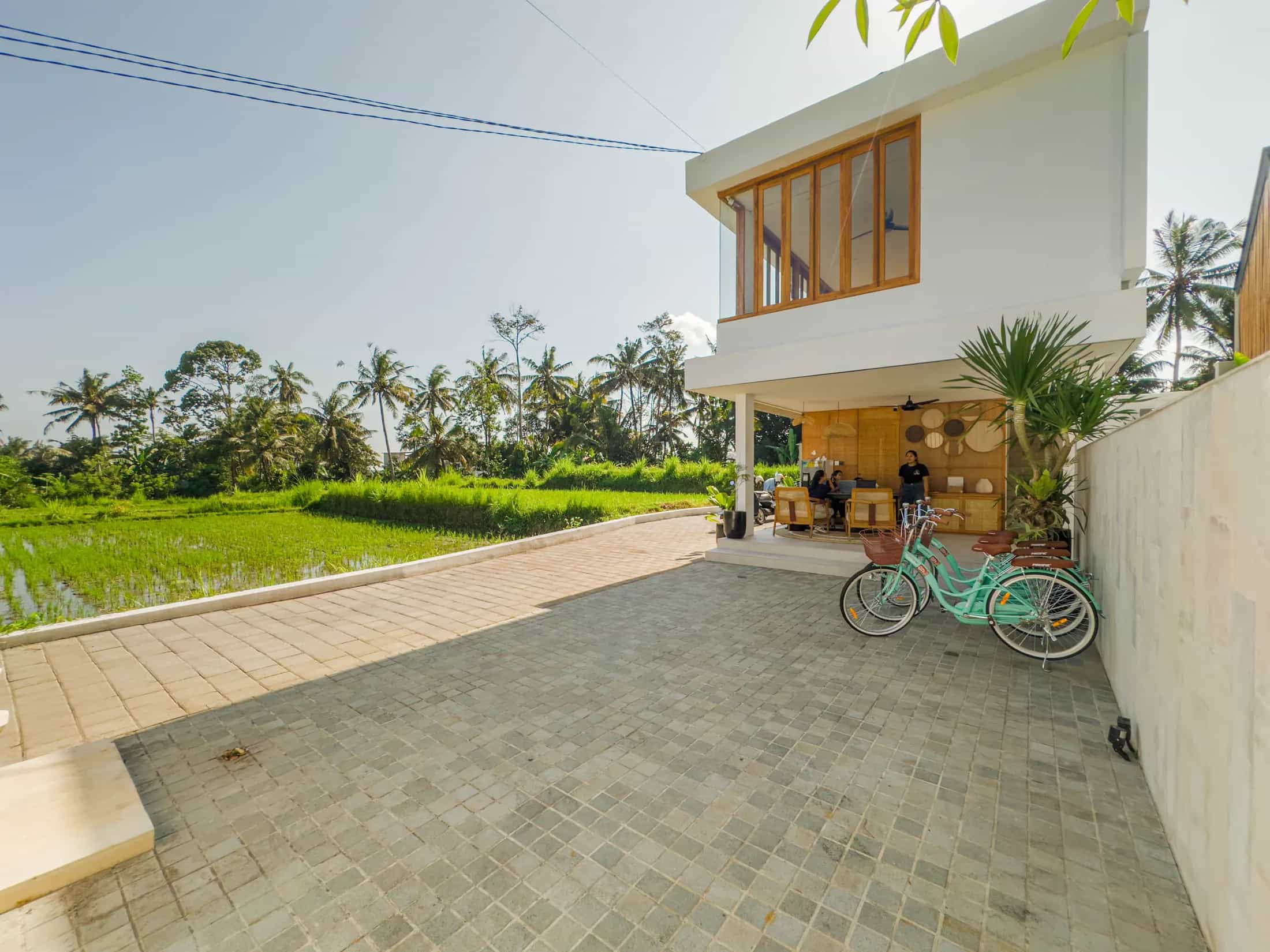 Bicycles outside Tannari Villas with rice fields and palms beyond
