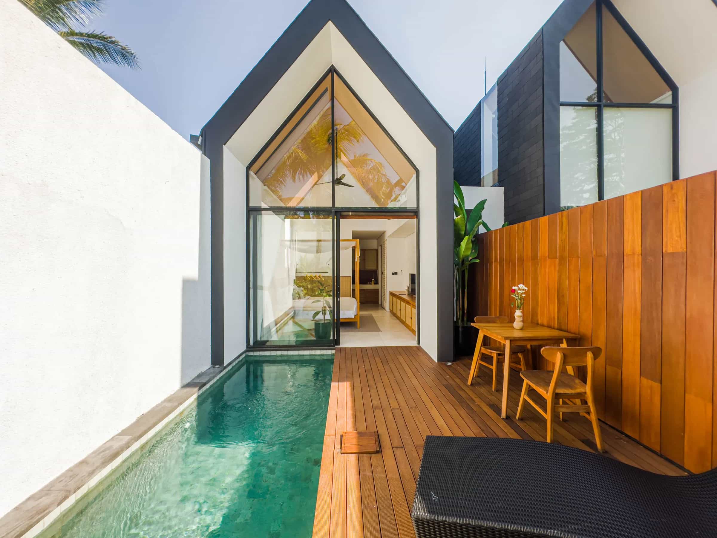 One Bedroom villa: private pool and teak deck leading to the glass A-frame facade, with a small dining table