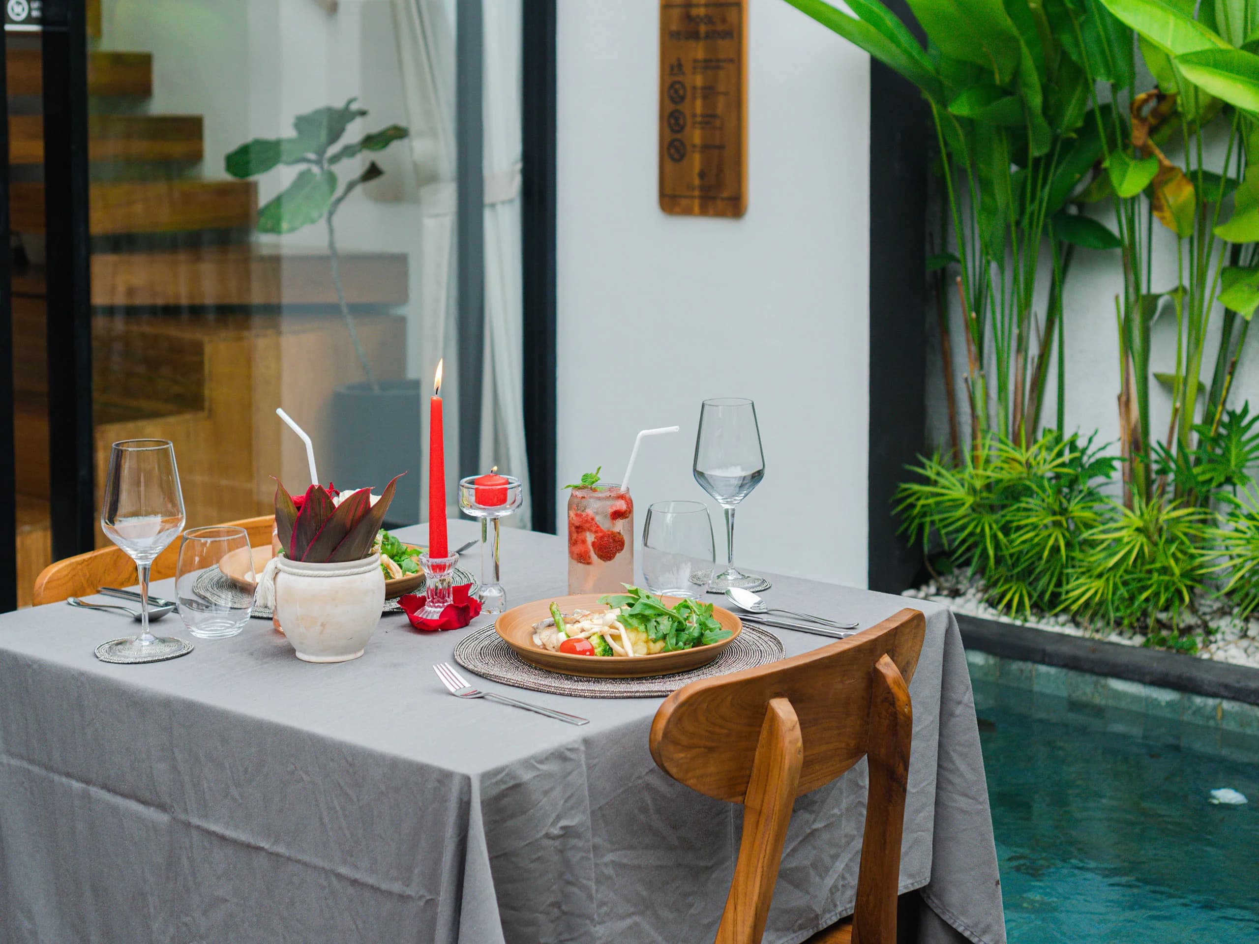 Romantic poolside dinner setup at Tannari Villas with candles and a private pool