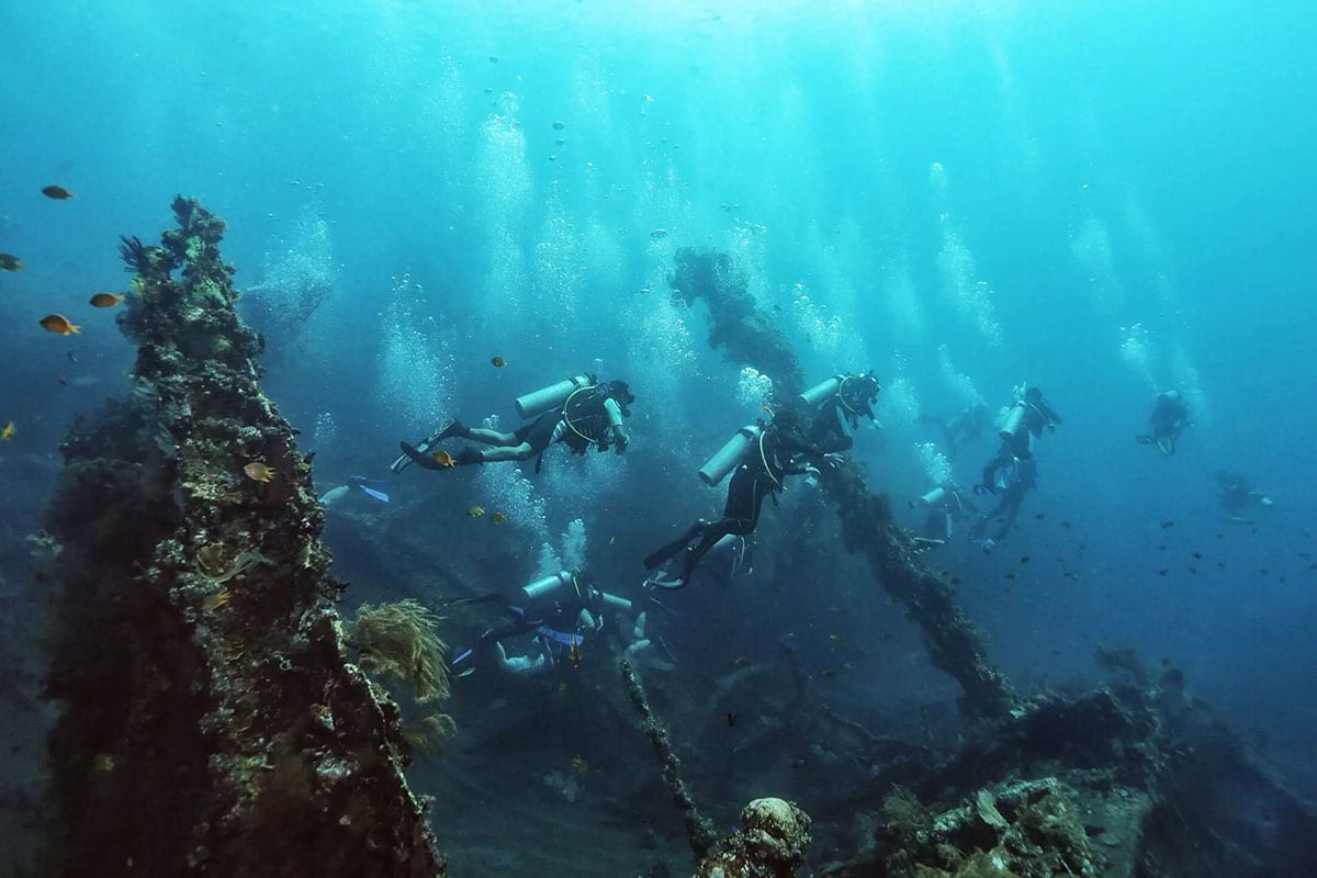 Scuba divers exploring the USAT Liberty shipwreck at Tulamben, Bali