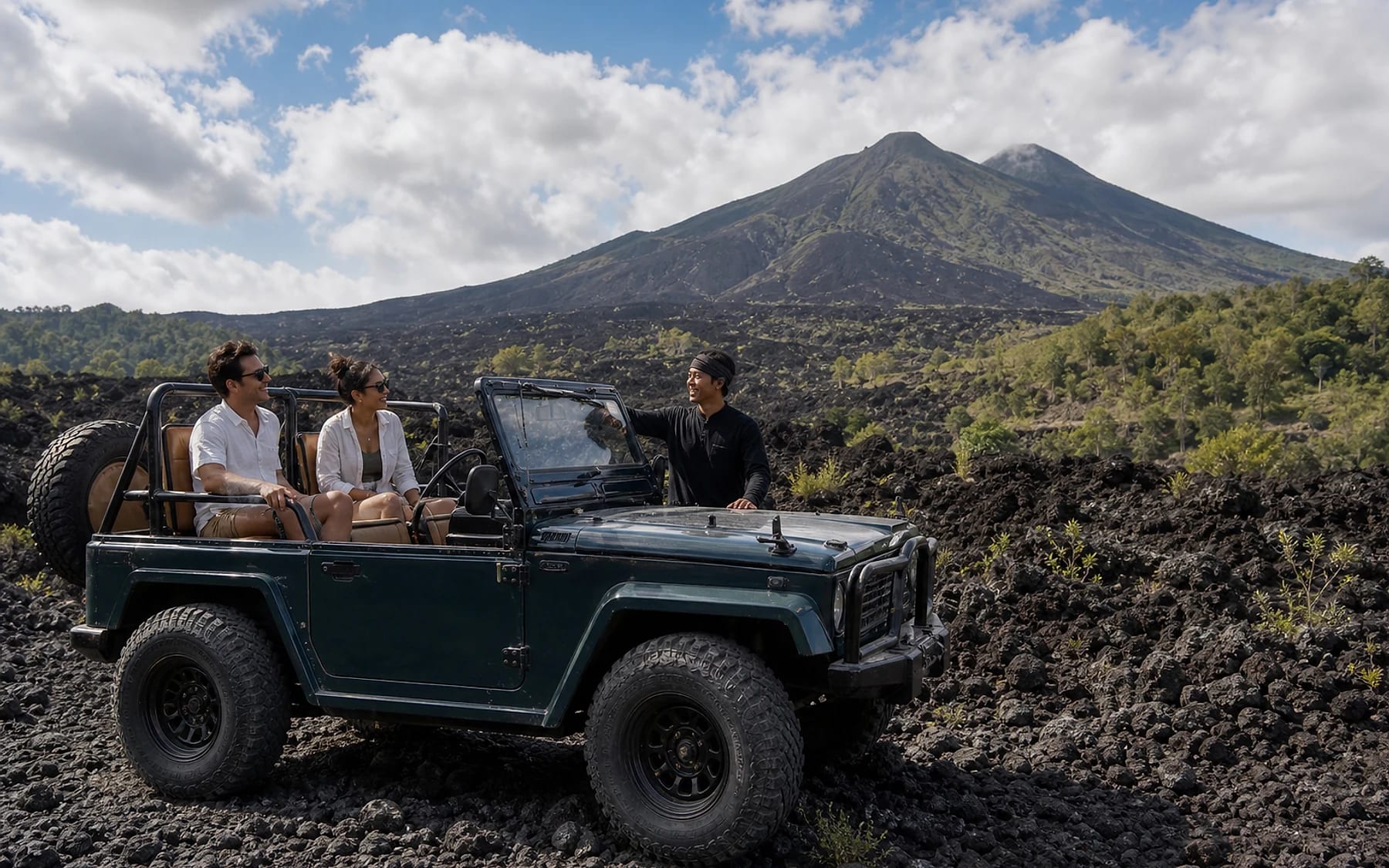 Open jeep and guests on the black lava fields below Mount Batur